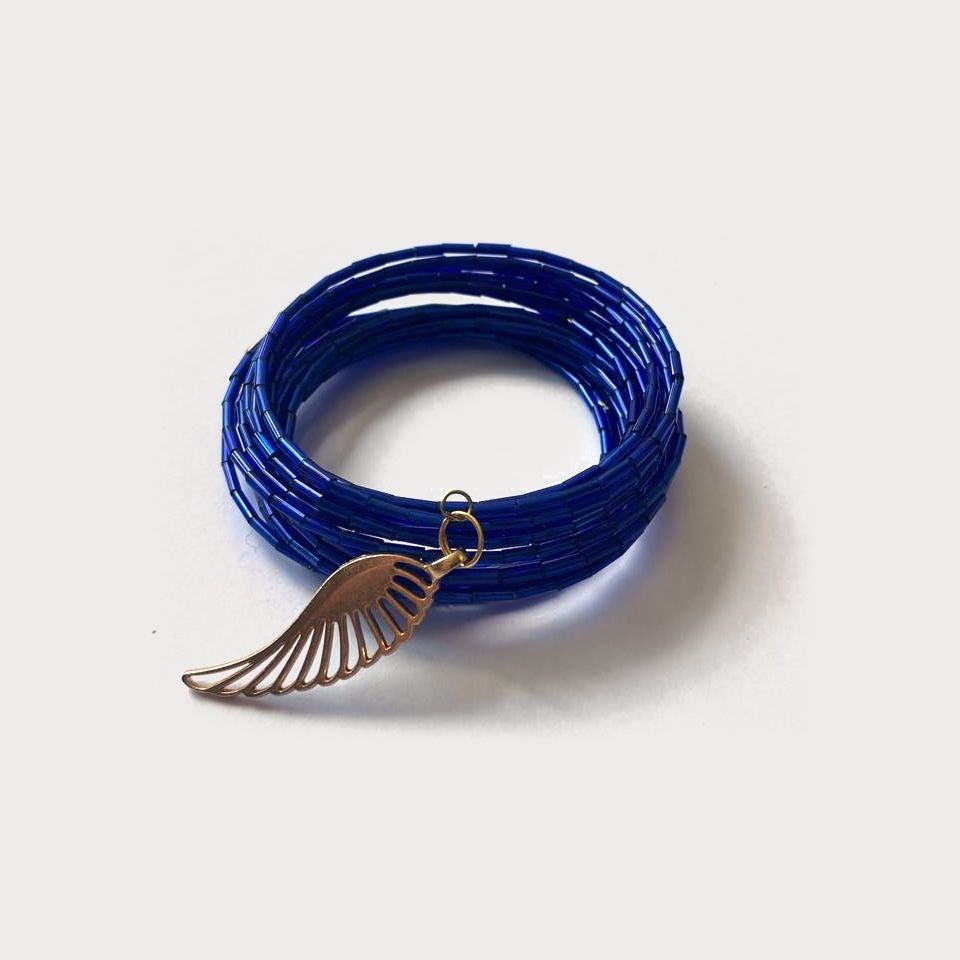 Pulsera Vuelo en espiral de vidrio azul rey con un dije de ala